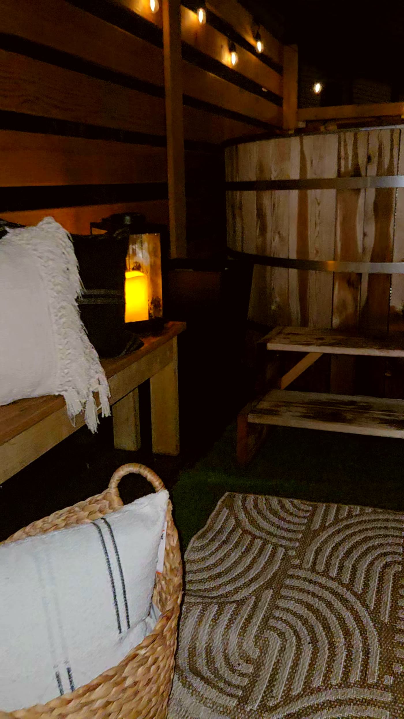 Cedar hot tub with wood-fire stove chimney at dusk